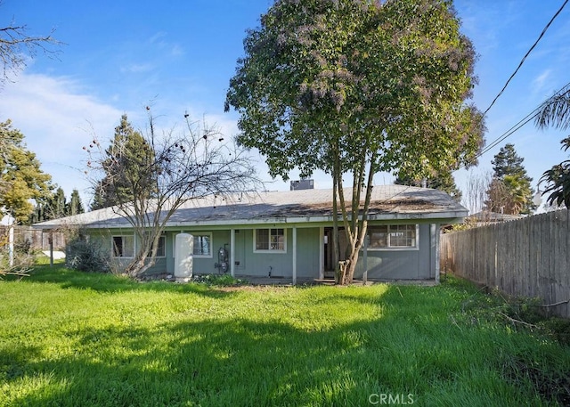 rear view of property with a yard