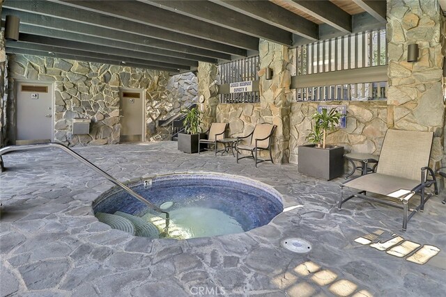 view of swimming pool with an indoor hot tub and a patio