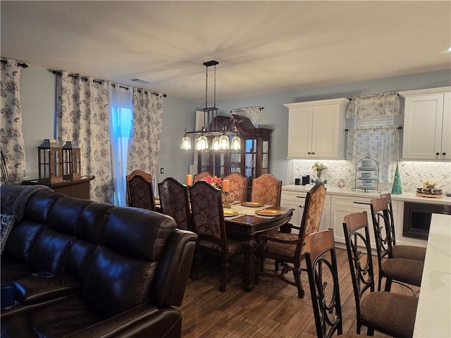 dining space with a chandelier and dark hardwood / wood-style flooring