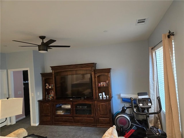 living room featuring dark carpet and ceiling fan