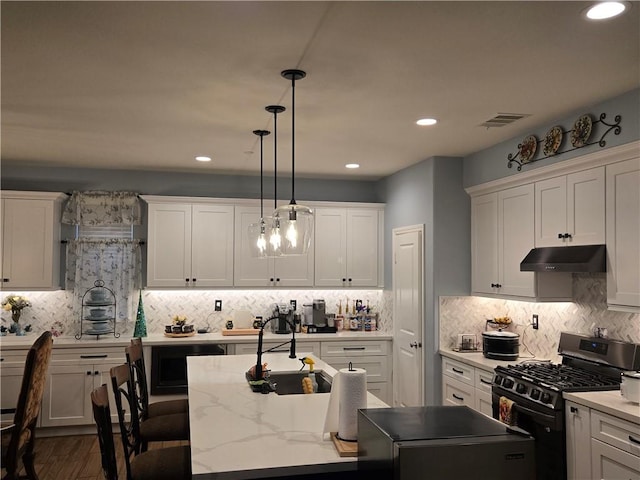 kitchen featuring white cabinets, decorative light fixtures, backsplash, and range with gas cooktop