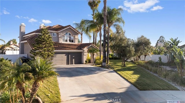 mediterranean / spanish-style home featuring a front lawn and a garage