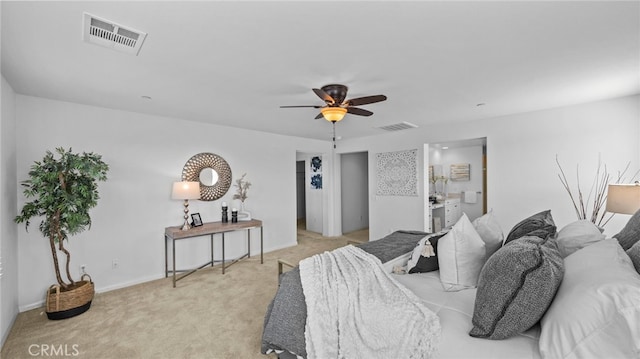 bedroom featuring ensuite bathroom, light colored carpet, and ceiling fan