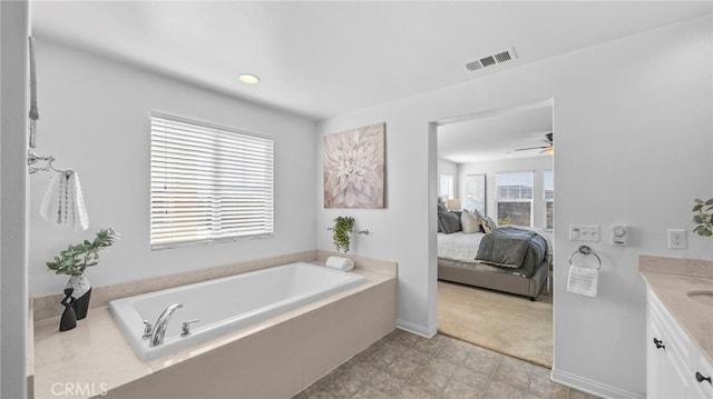 bathroom featuring vanity, a tub, and ceiling fan