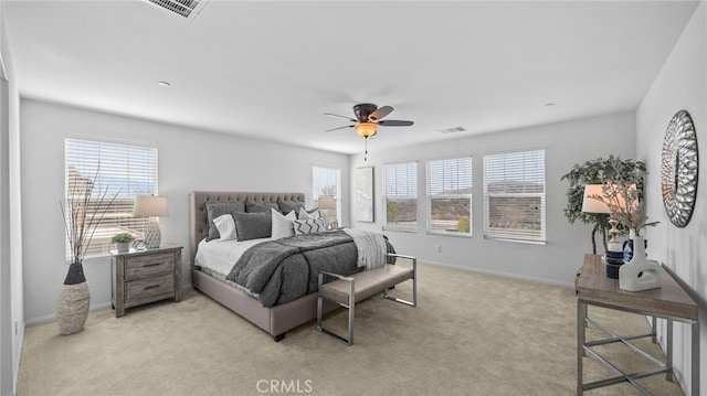 bedroom featuring multiple windows, light colored carpet, and ceiling fan