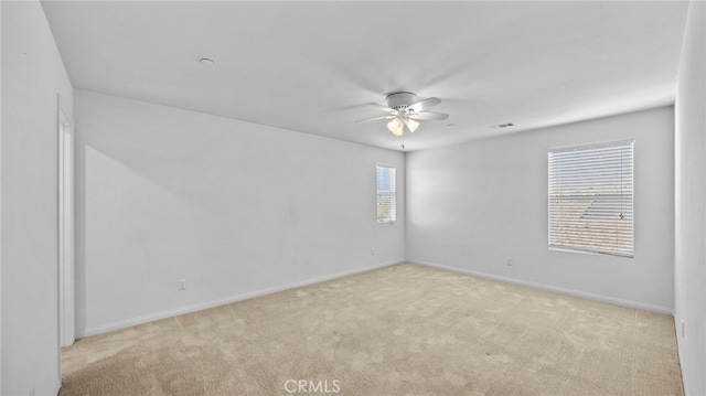 carpeted spare room featuring ceiling fan