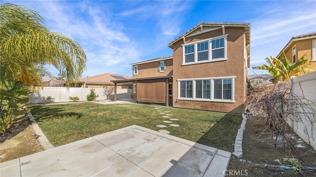 rear view of house featuring a yard and a patio area