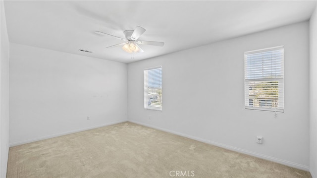 carpeted spare room with ceiling fan