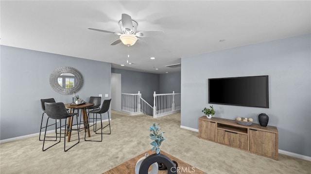 carpeted living room with ceiling fan