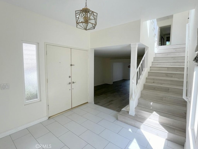 tiled foyer featuring a chandelier