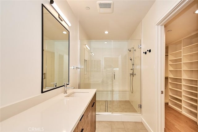 bathroom with tile patterned flooring, vanity, and a shower with shower door