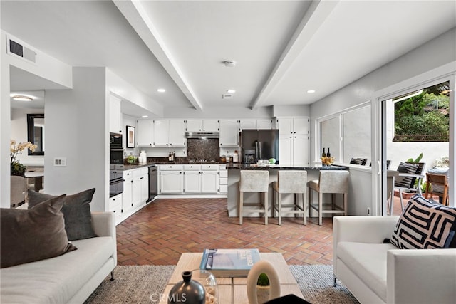 living room featuring beamed ceiling