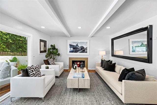 living room featuring a brick fireplace and beamed ceiling