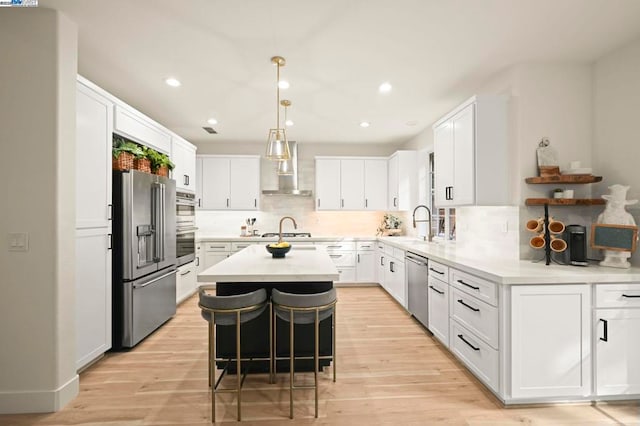 kitchen with a kitchen breakfast bar, white cabinets, appliances with stainless steel finishes, and a center island