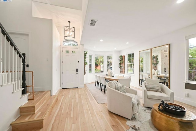 entrance foyer featuring light hardwood / wood-style flooring and a notable chandelier