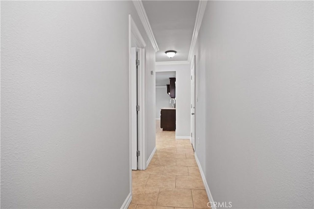 hallway featuring crown molding and light tile patterned floors