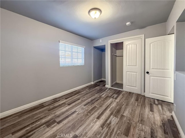 unfurnished bedroom with dark hardwood / wood-style floors and a closet