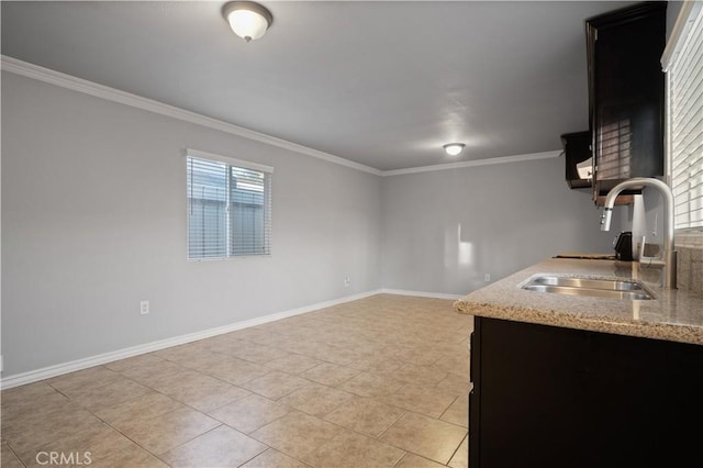 kitchen featuring crown molding, light stone countertops, sink, and light tile patterned floors