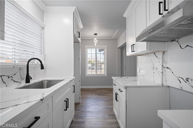 kitchen featuring extractor fan, sink, white cabinets, and decorative light fixtures