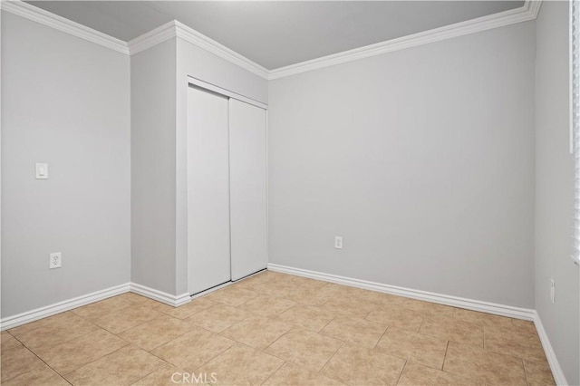 unfurnished bedroom featuring crown molding, light tile patterned floors, and a closet