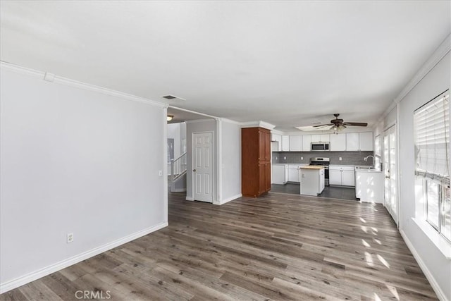 unfurnished living room featuring dark hardwood / wood-style floors, ceiling fan, ornamental molding, and sink