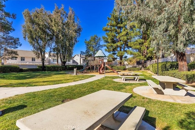 view of home's community featuring a playground and a yard