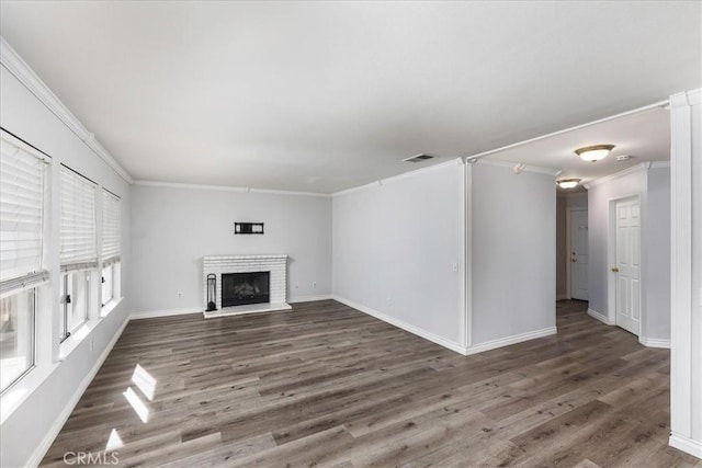 unfurnished living room featuring a fireplace, crown molding, and dark hardwood / wood-style flooring