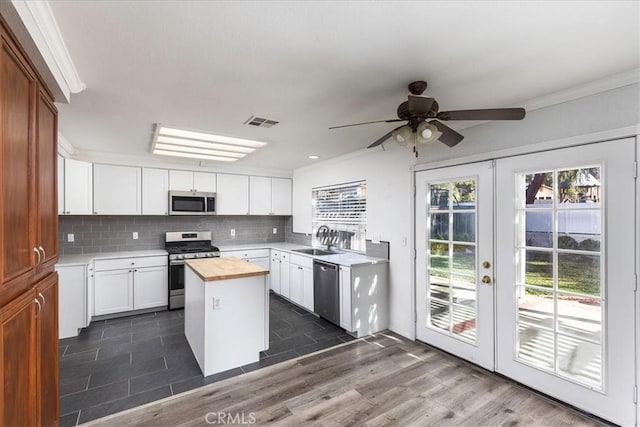 kitchen featuring french doors, white cabinets, butcher block countertops, a kitchen island, and stainless steel appliances