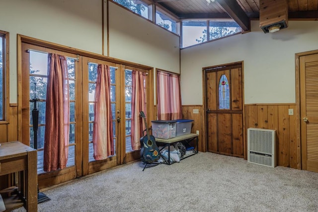 misc room featuring beam ceiling, heating unit, a wealth of natural light, and carpet flooring