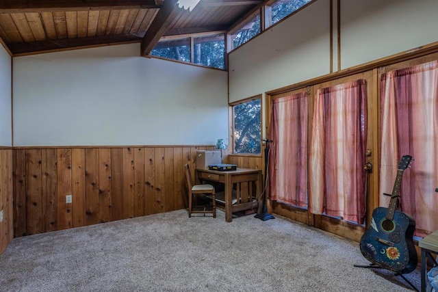 interior space with wooden walls, vaulted ceiling with beams, carpet floors, and wooden ceiling