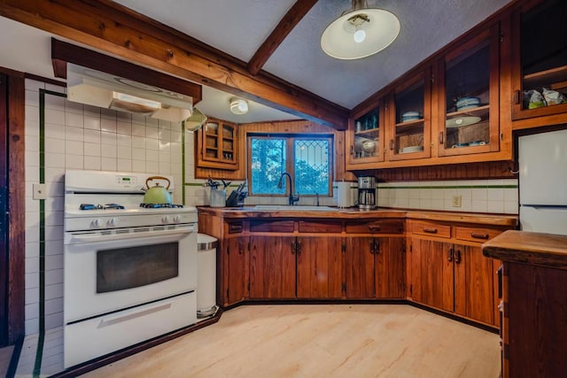 kitchen featuring decorative backsplash, white appliances, ventilation hood, sink, and beam ceiling