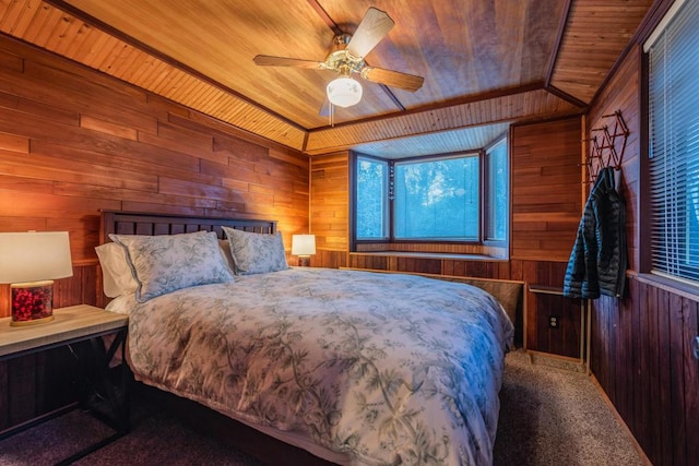 carpeted bedroom with ceiling fan, wooden walls, and wooden ceiling