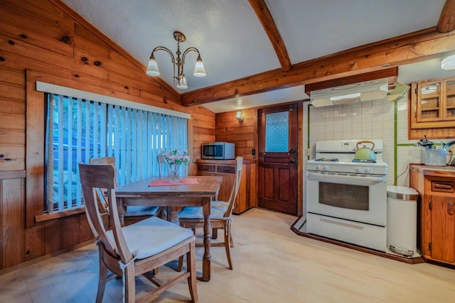 dining area featuring vaulted ceiling with beams and a chandelier