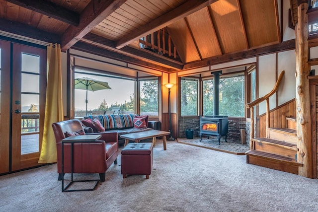 sunroom / solarium with a wood stove, lofted ceiling with beams, and wood ceiling