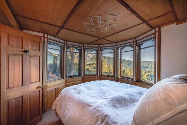 carpeted bedroom with a mountain view and wood ceiling