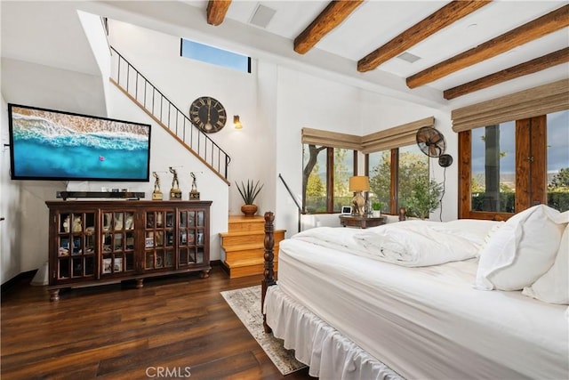 bedroom with dark wood-type flooring and beam ceiling