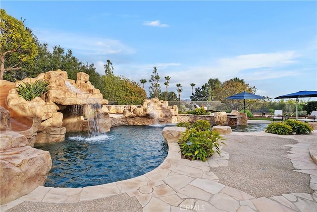 view of swimming pool featuring pool water feature and a patio area