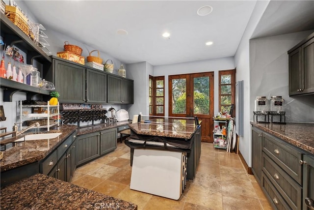 kitchen with french doors, backsplash, a kitchen island, and dark stone countertops