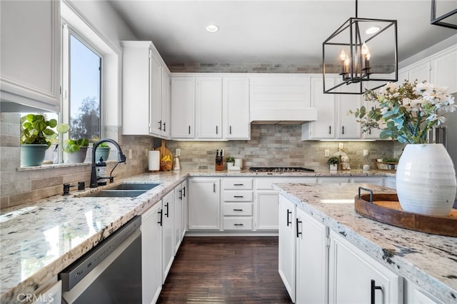 kitchen featuring sink, white cabinetry, decorative light fixtures, appliances with stainless steel finishes, and dark hardwood / wood-style flooring