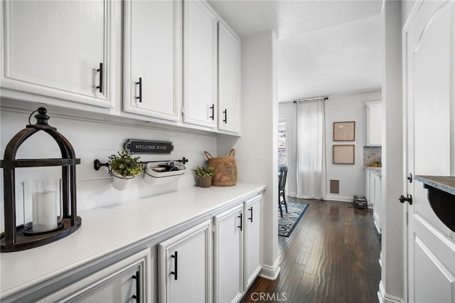 interior space with white cabinetry and dark wood-type flooring