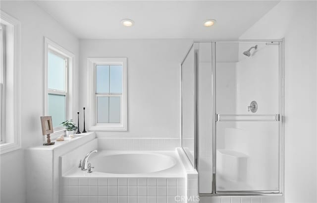 bathroom featuring shower with separate bathtub