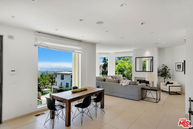 tiled dining room featuring a healthy amount of sunlight