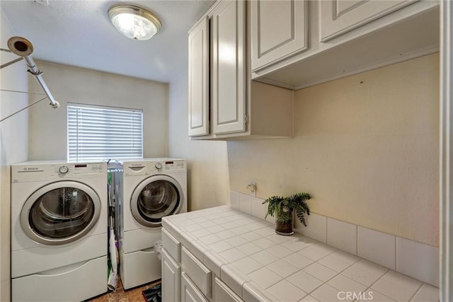 laundry area featuring washer and dryer and cabinets