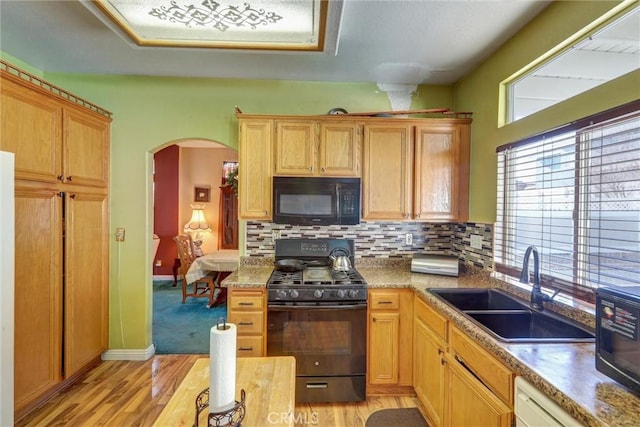 kitchen featuring black appliances, light hardwood / wood-style flooring, sink, and tasteful backsplash