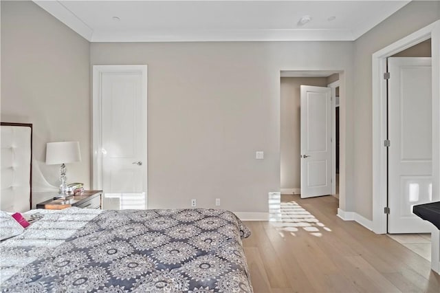 bedroom with light hardwood / wood-style flooring and crown molding