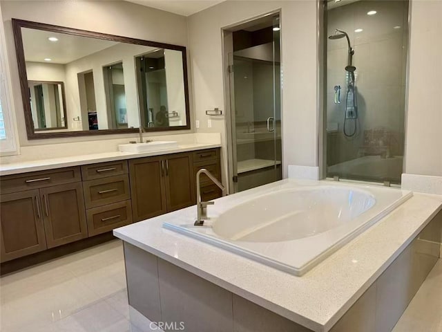 bathroom featuring tile patterned flooring, vanity, and shower with separate bathtub