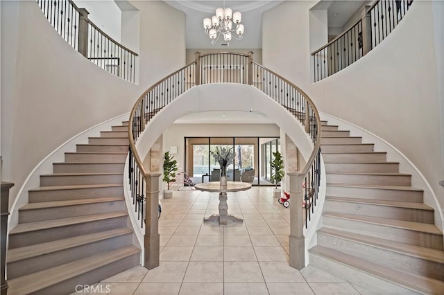 tiled entryway with a towering ceiling and an inviting chandelier