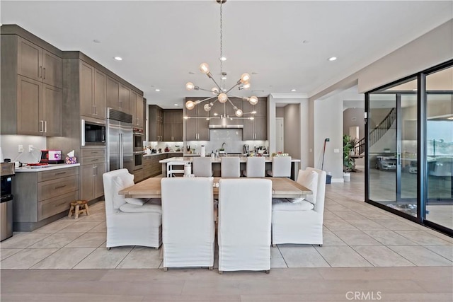 dining area with sink, a chandelier, and light tile patterned floors