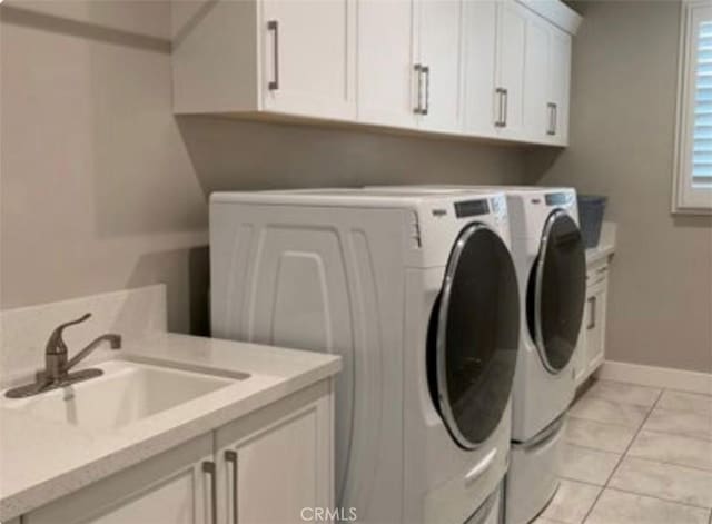 clothes washing area with sink, light tile patterned floors, cabinets, and independent washer and dryer