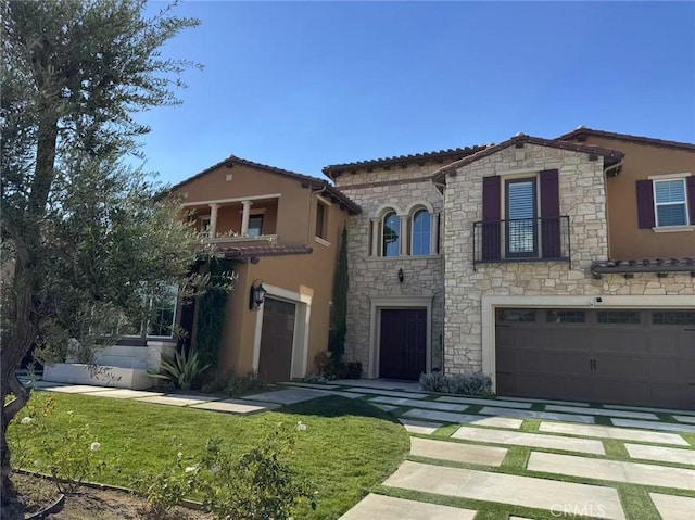 mediterranean / spanish house with a garage and a front lawn